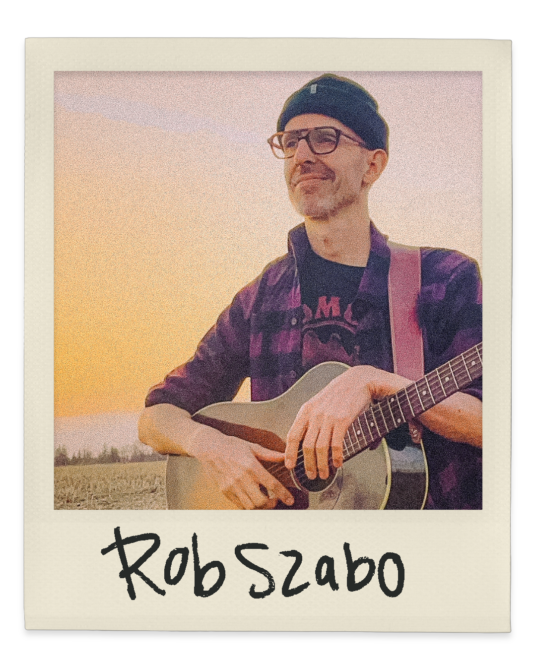Polaroid portrait of Rob Szabo smiling and holding a guitar with handwritten label.