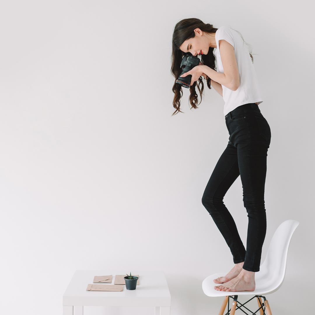brunette female in content creation mode using a professional camera for her personal branding campaign the Maxwell Method