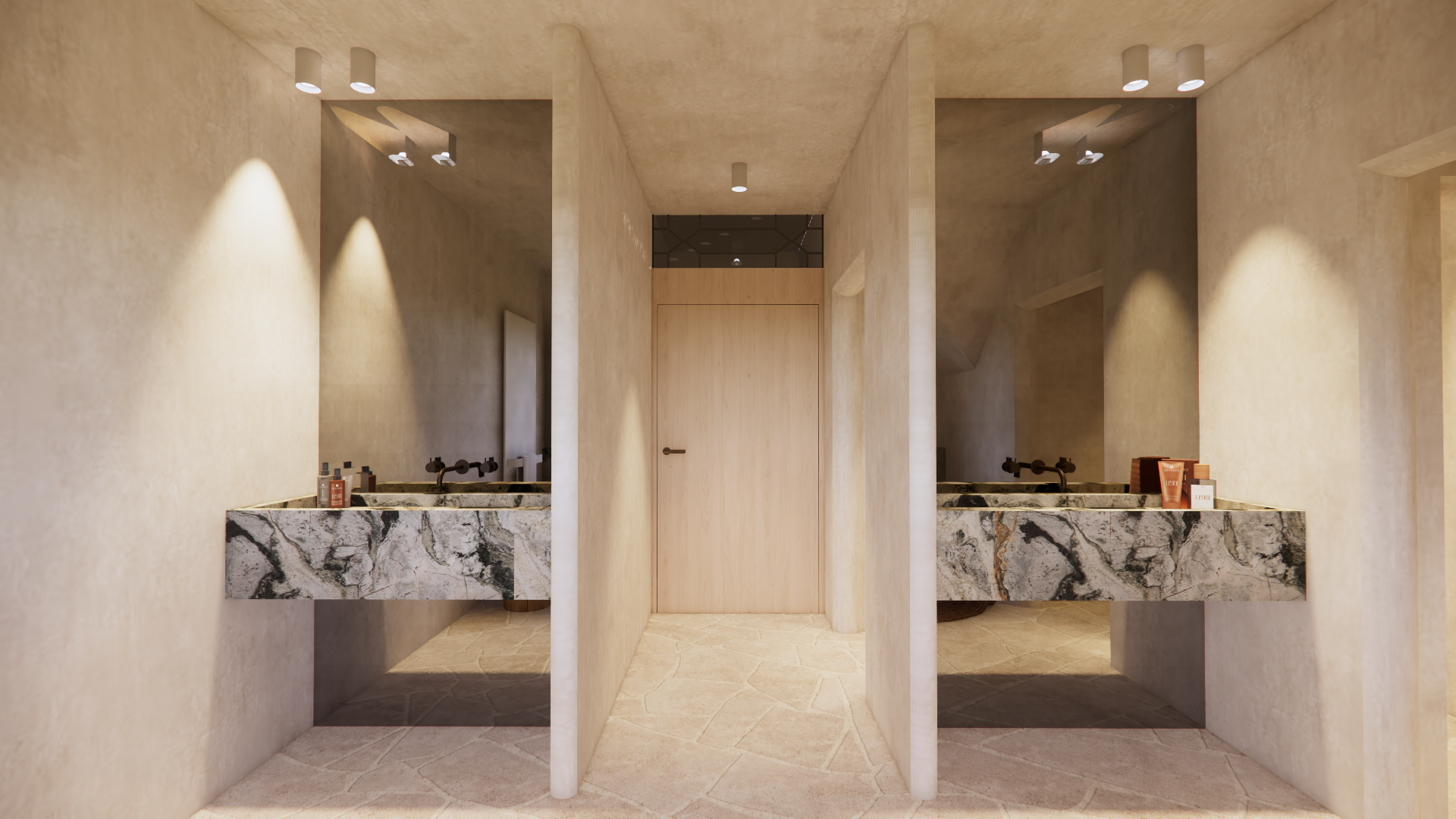 Public restroom with dual marble sinks, each with a black faucet, soap, and hand lotion, divided by a beige wall, illuminated by ceiling spotlights.