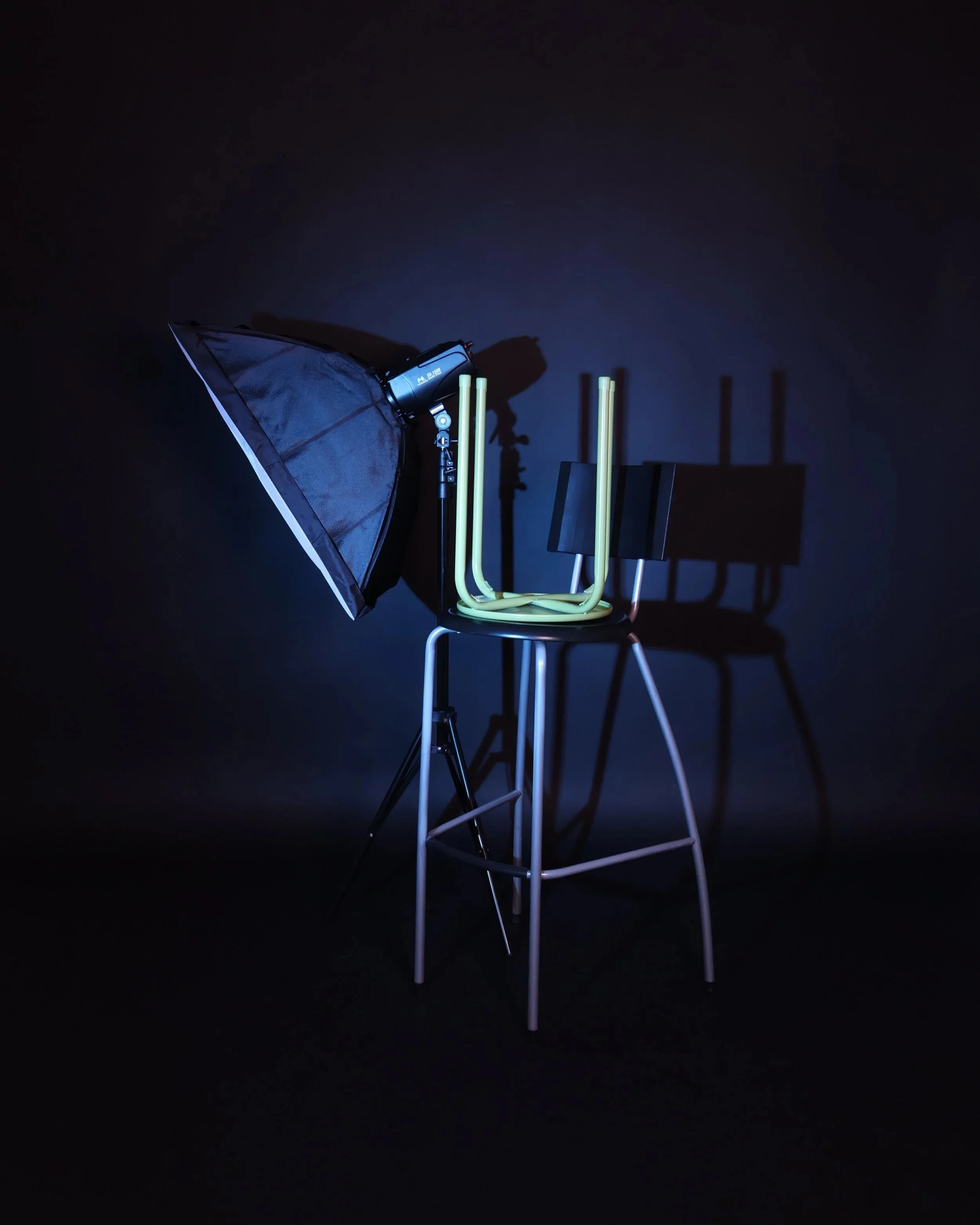 Valokuva studiovaloisteesta, jossa on kaksi tuolia, yksi pöytä, videovalo ja katos.