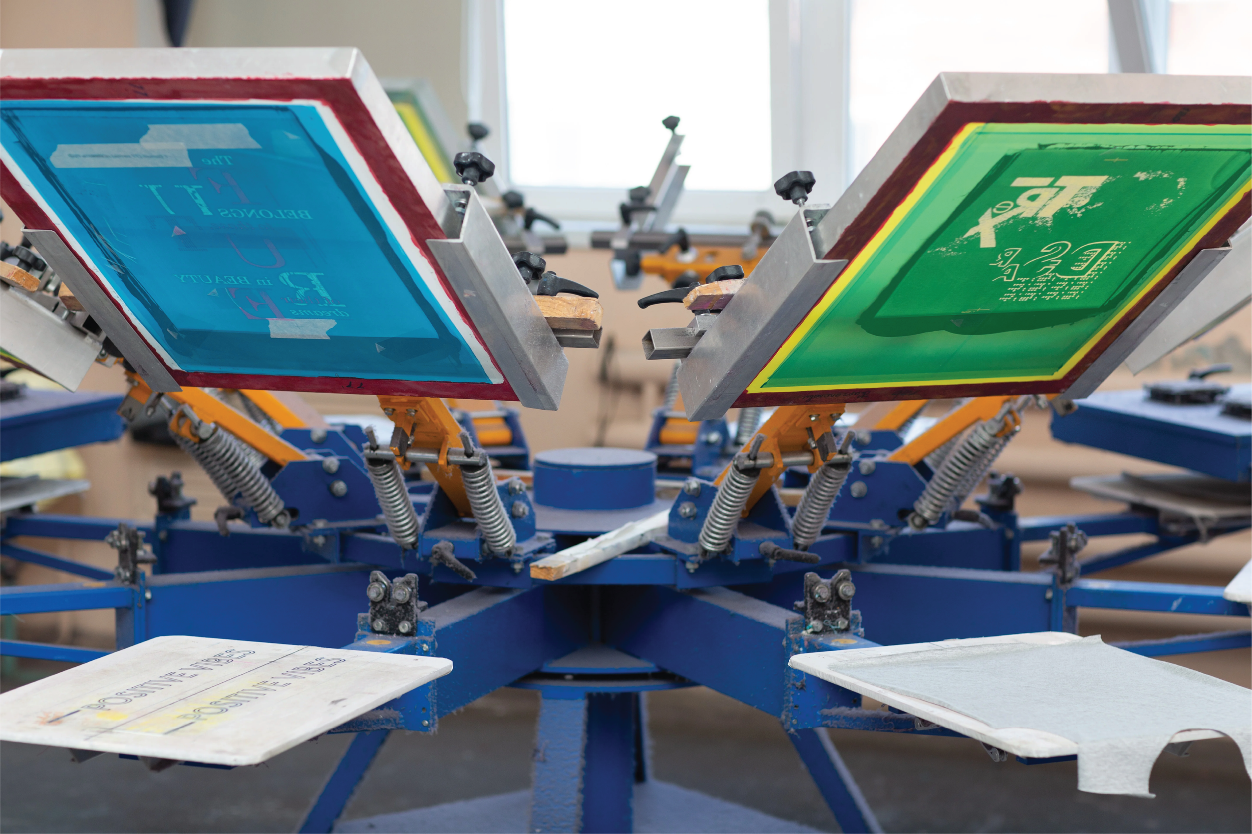 Screen printing machine with colorful screens for printing on textiles.