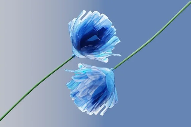 Digital illustration of two blue flowers with green stems, mirrored against a gray background.
