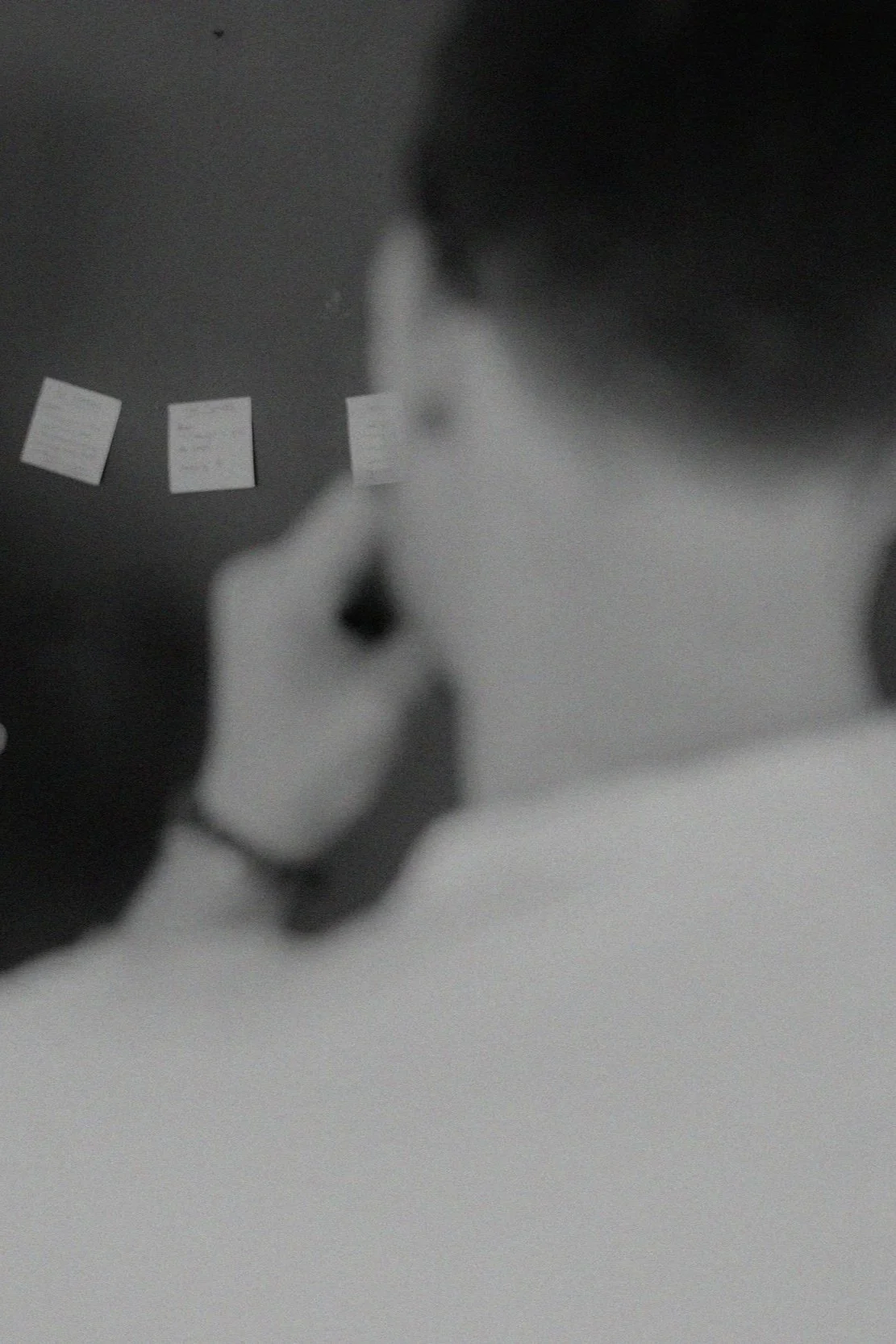 Black and white photo of a strategist reviewing sticky notes on a wall