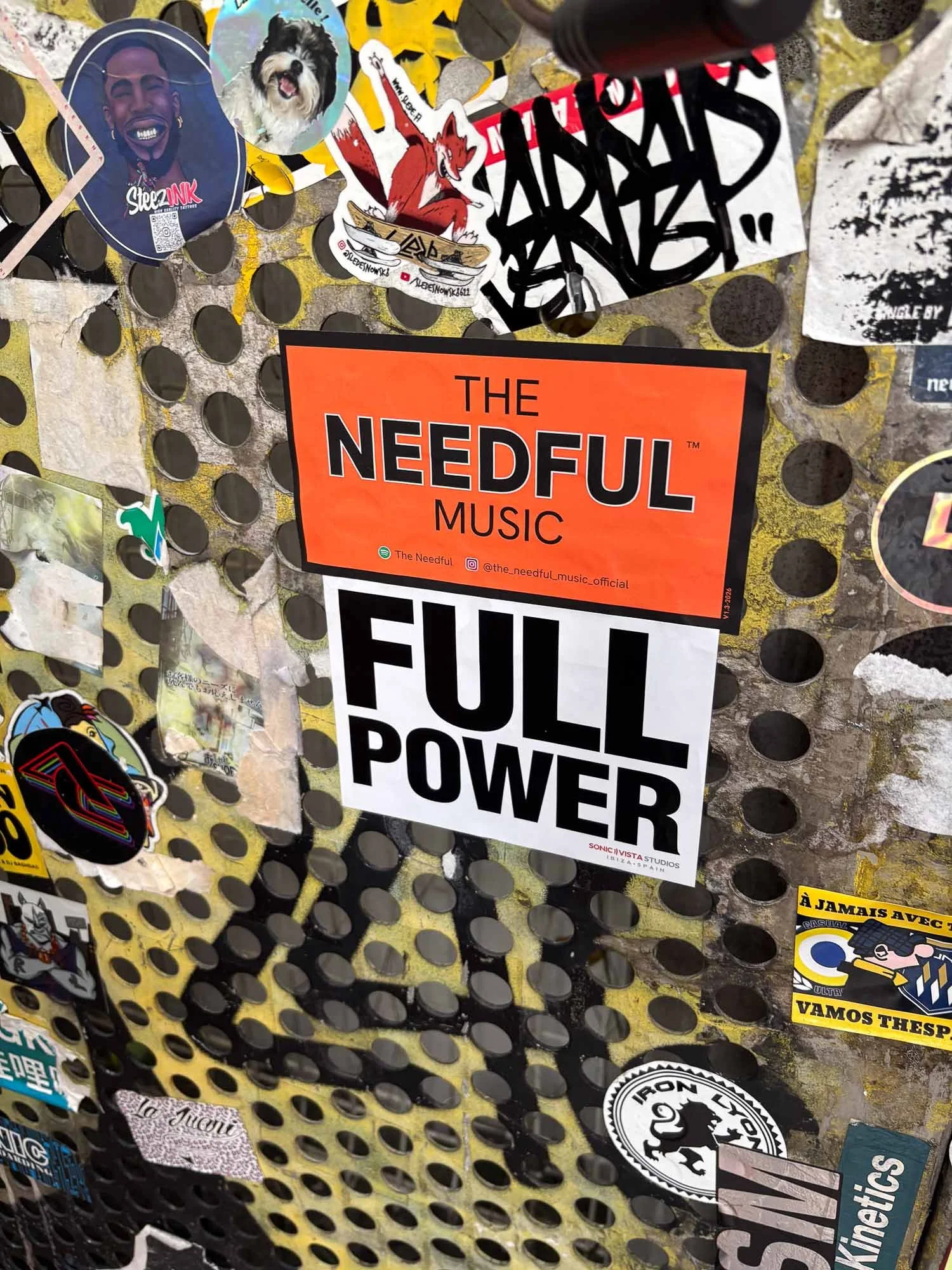 the-neeful-music-sticker-orange-on-yellow-metal-grid.jpg