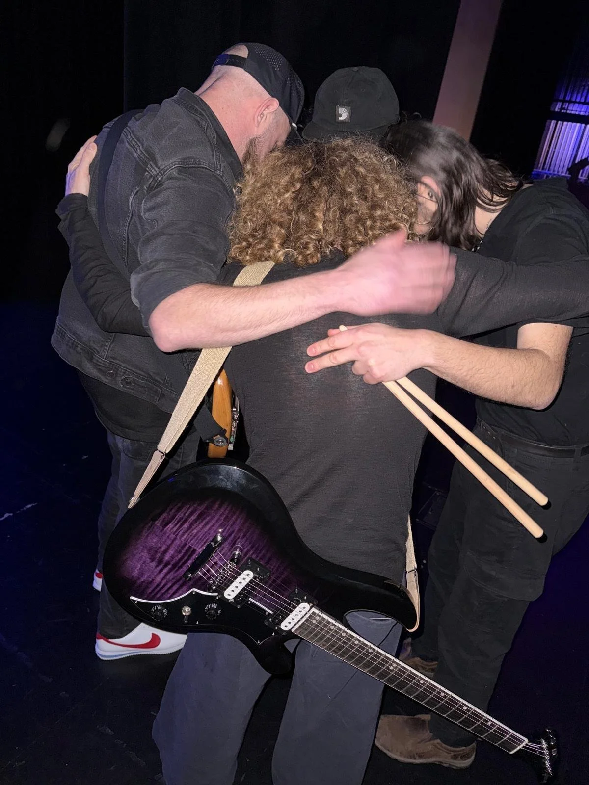 The Needful huddle backstage before a sold-out performance