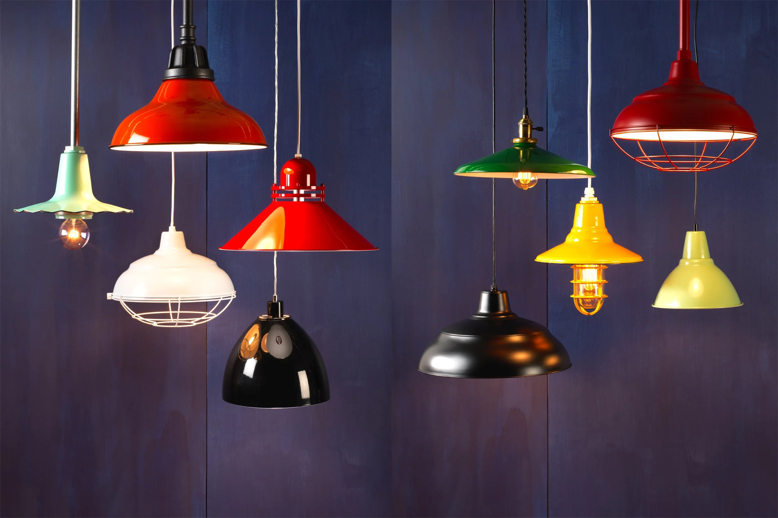 Multiple colorful pendant lights hanging against a dark wall.