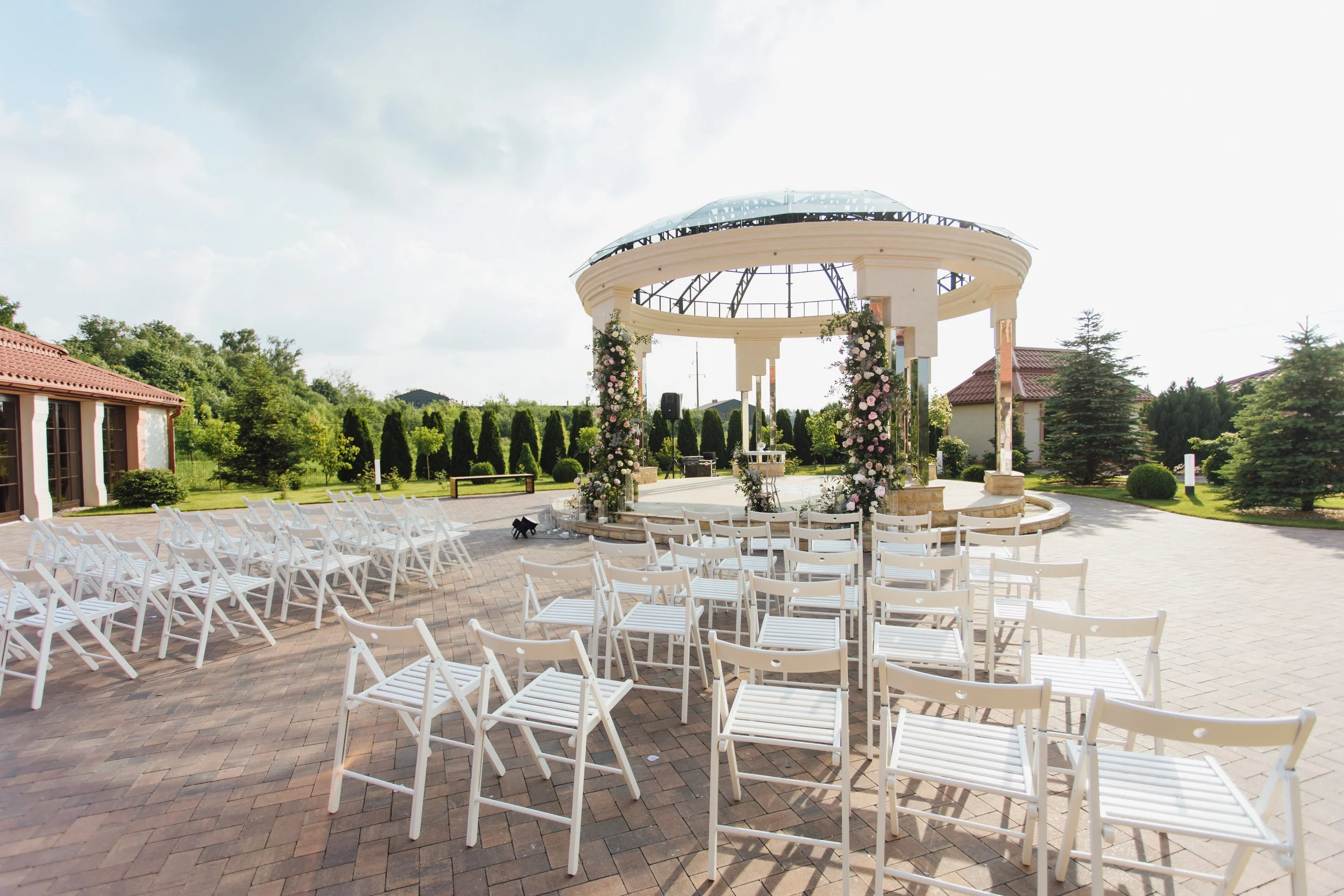 view-white-guest-chairs-decorated-ceremonial-archway-open-air-sunny-day.jpg