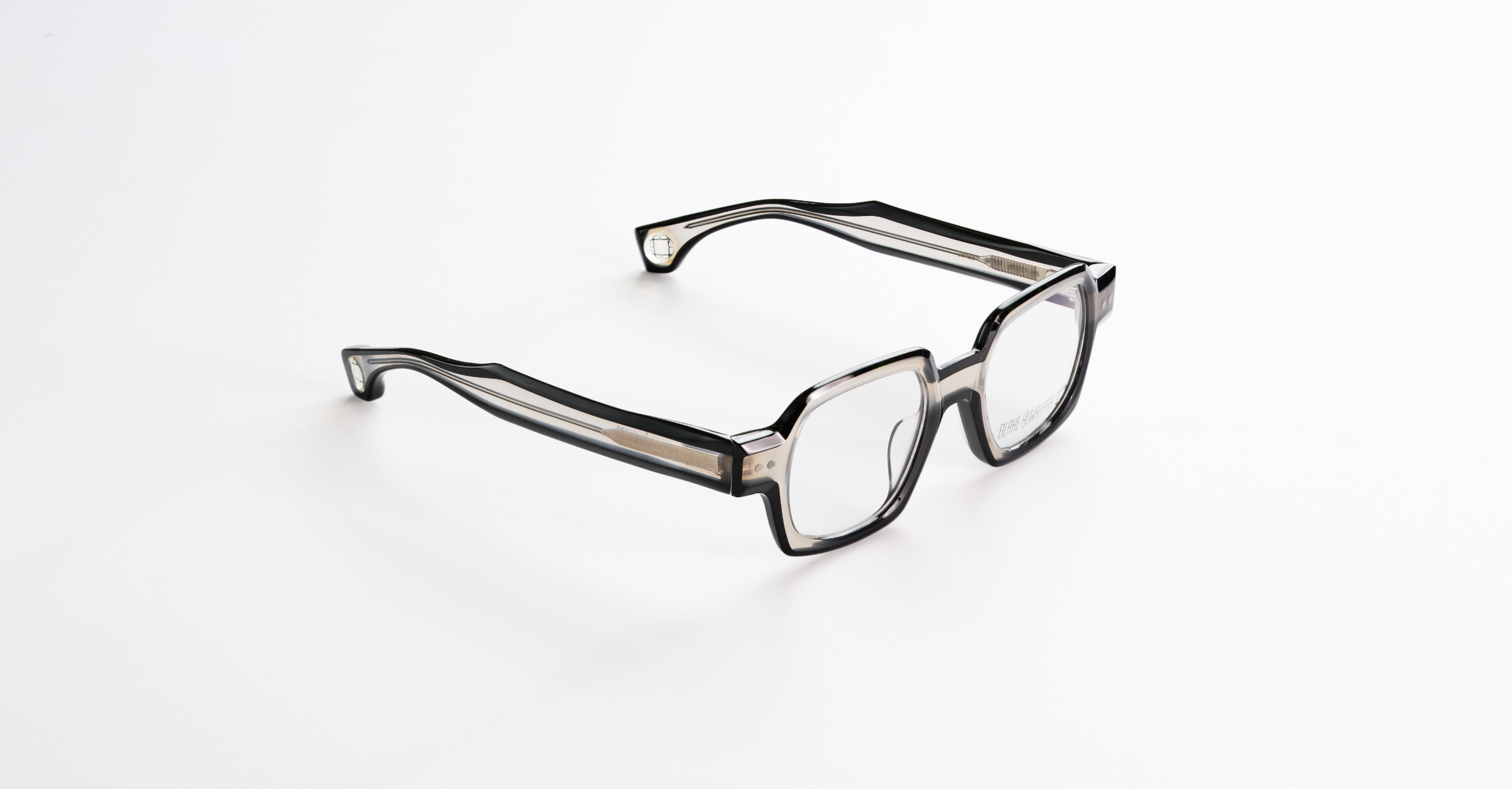 A pair of Blake Kuwahara black and clear eyeglasses on a white background.