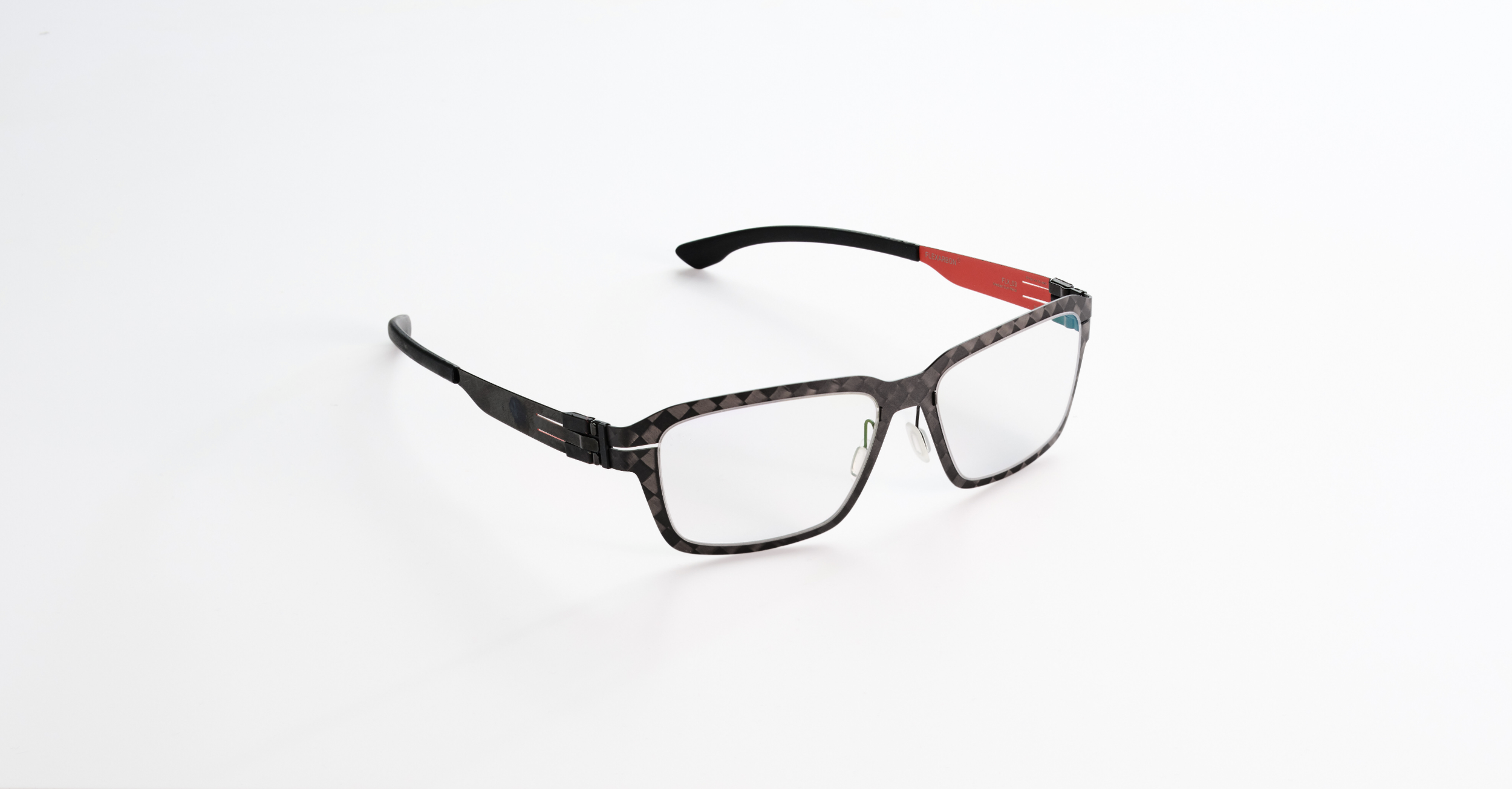 A pair of Ici Berlin eyeglasses with a patterned frame and clear lenses on a white background.