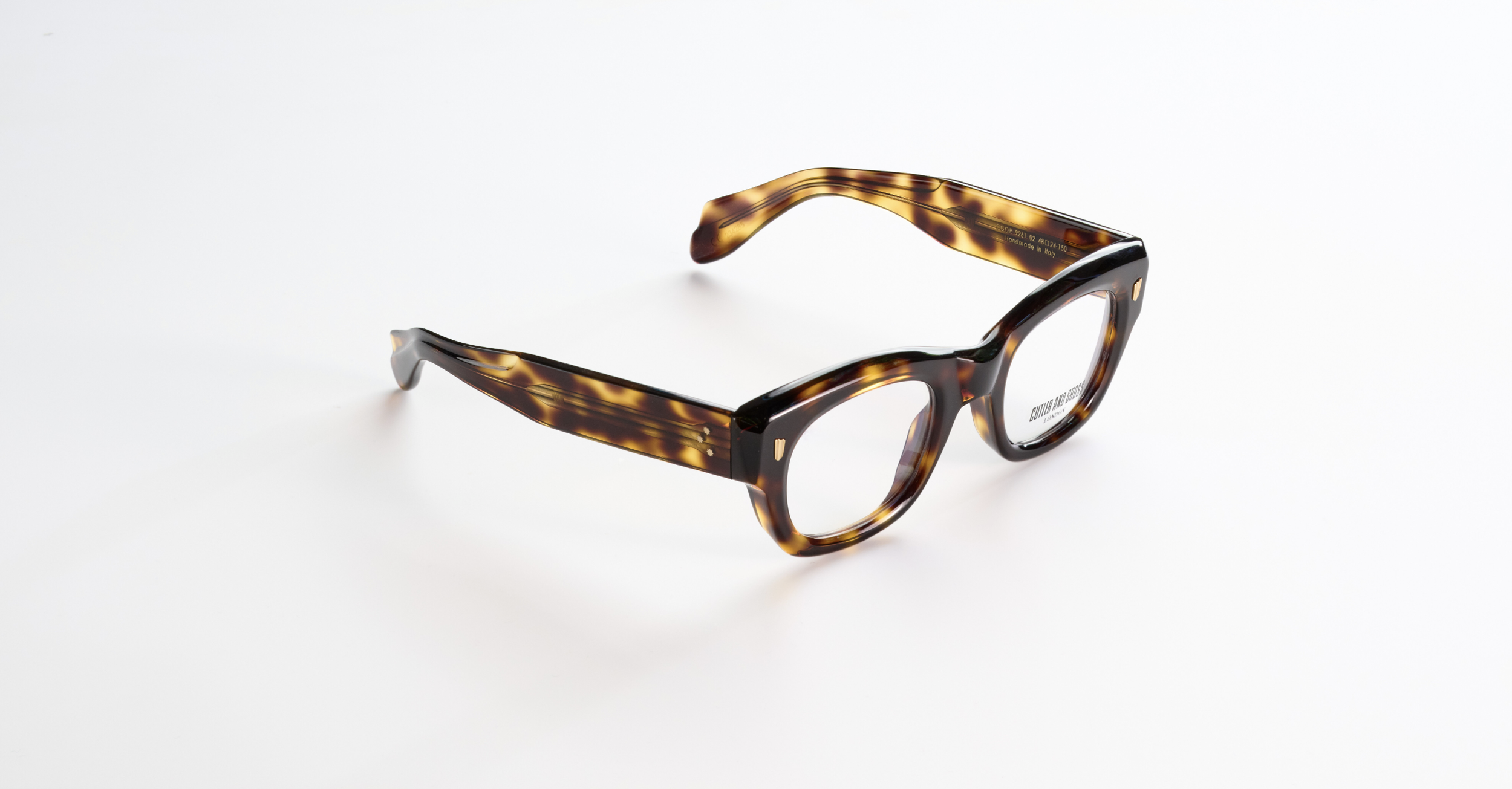 A pair of Cutler & Goss tortoiseshell patterned eyeglasses on a white surface