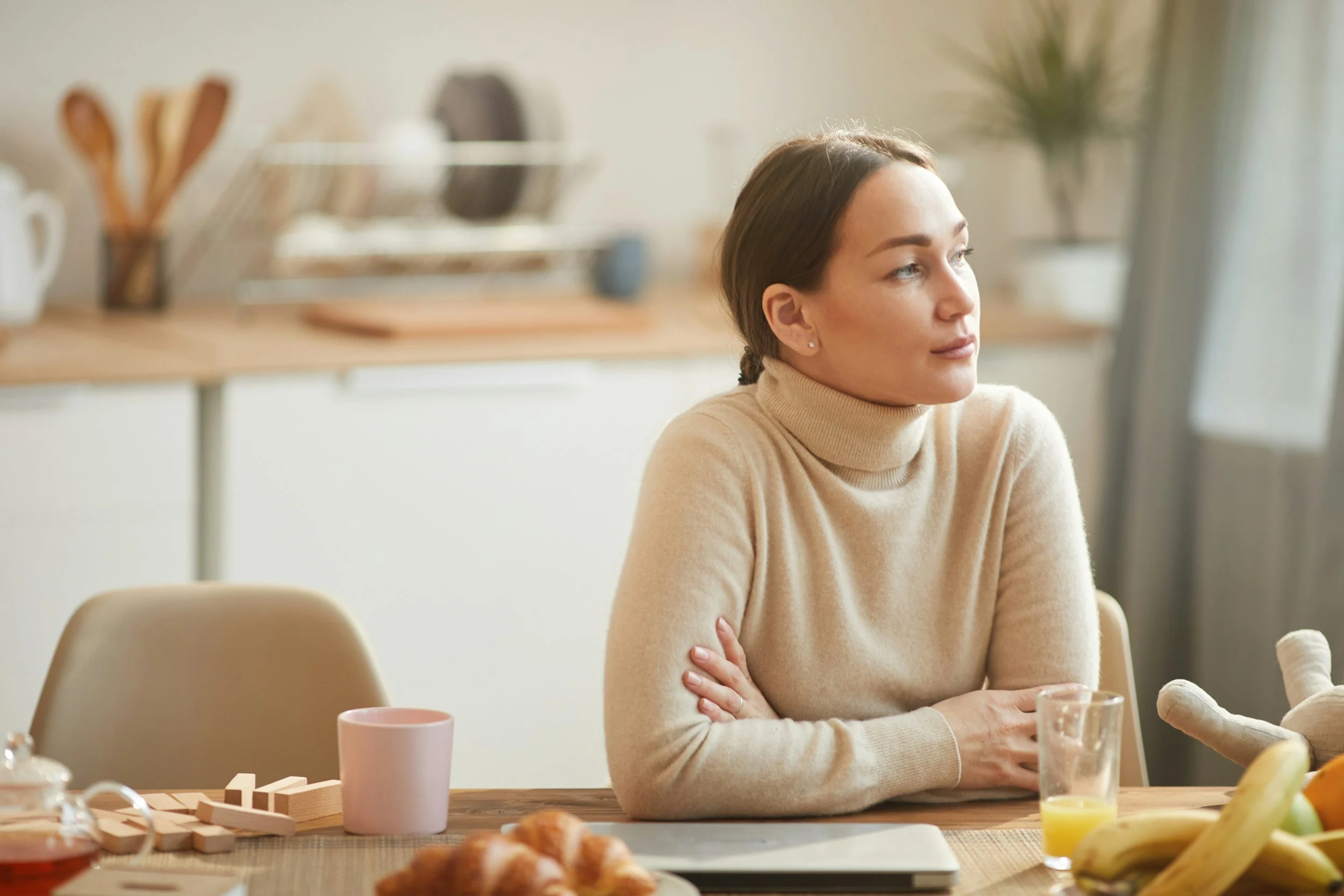 a woman sits at her office desk, tiredly looking out the window