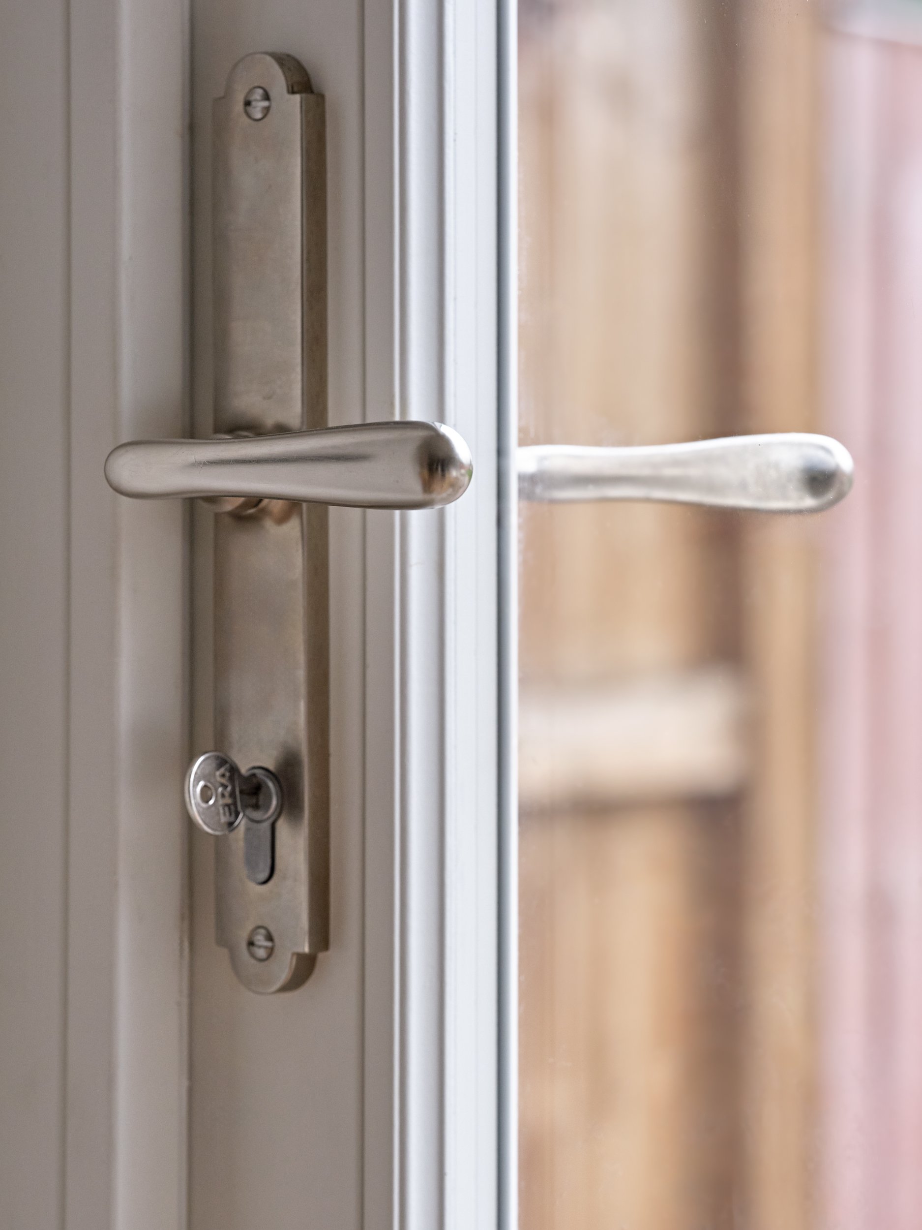 Close-up of a door handle and lock on a glass door with a metal frame.