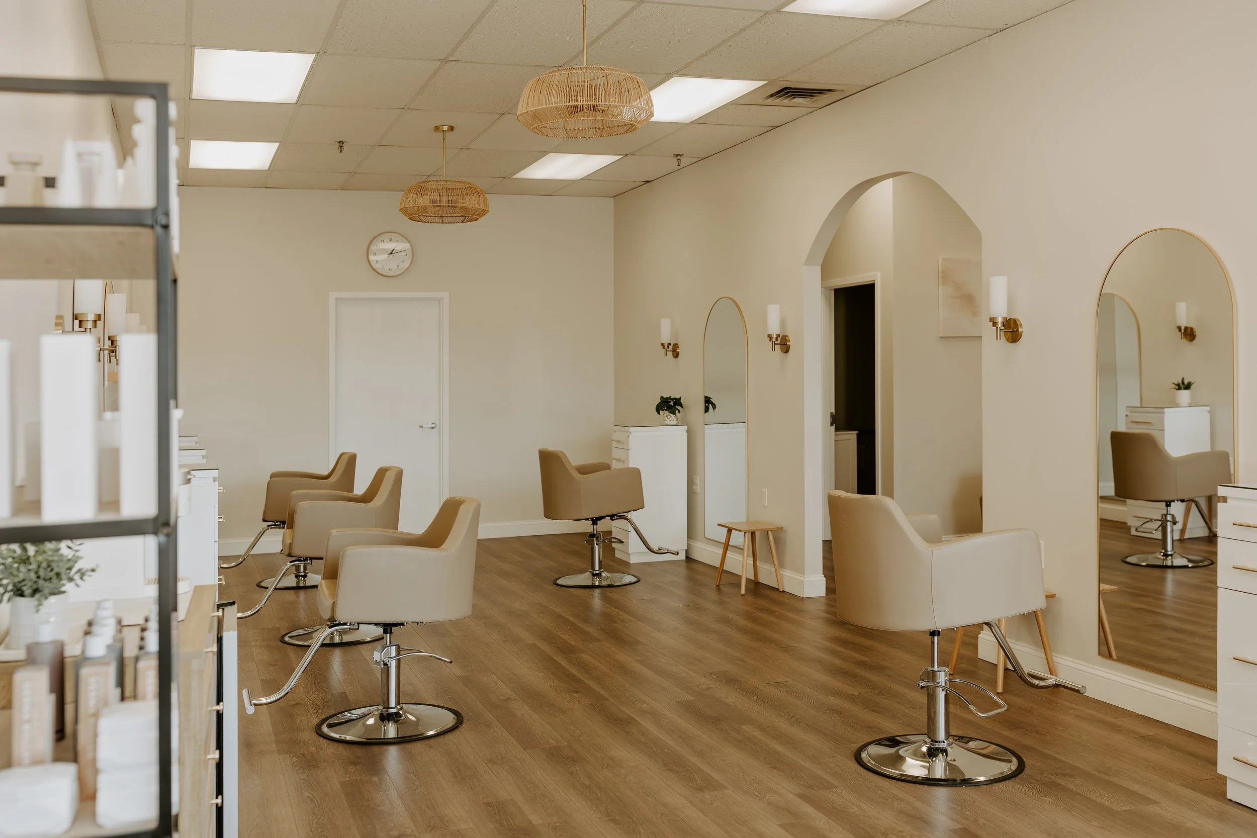 Empty hair salon with chairs, mirrors, and wooden decor.