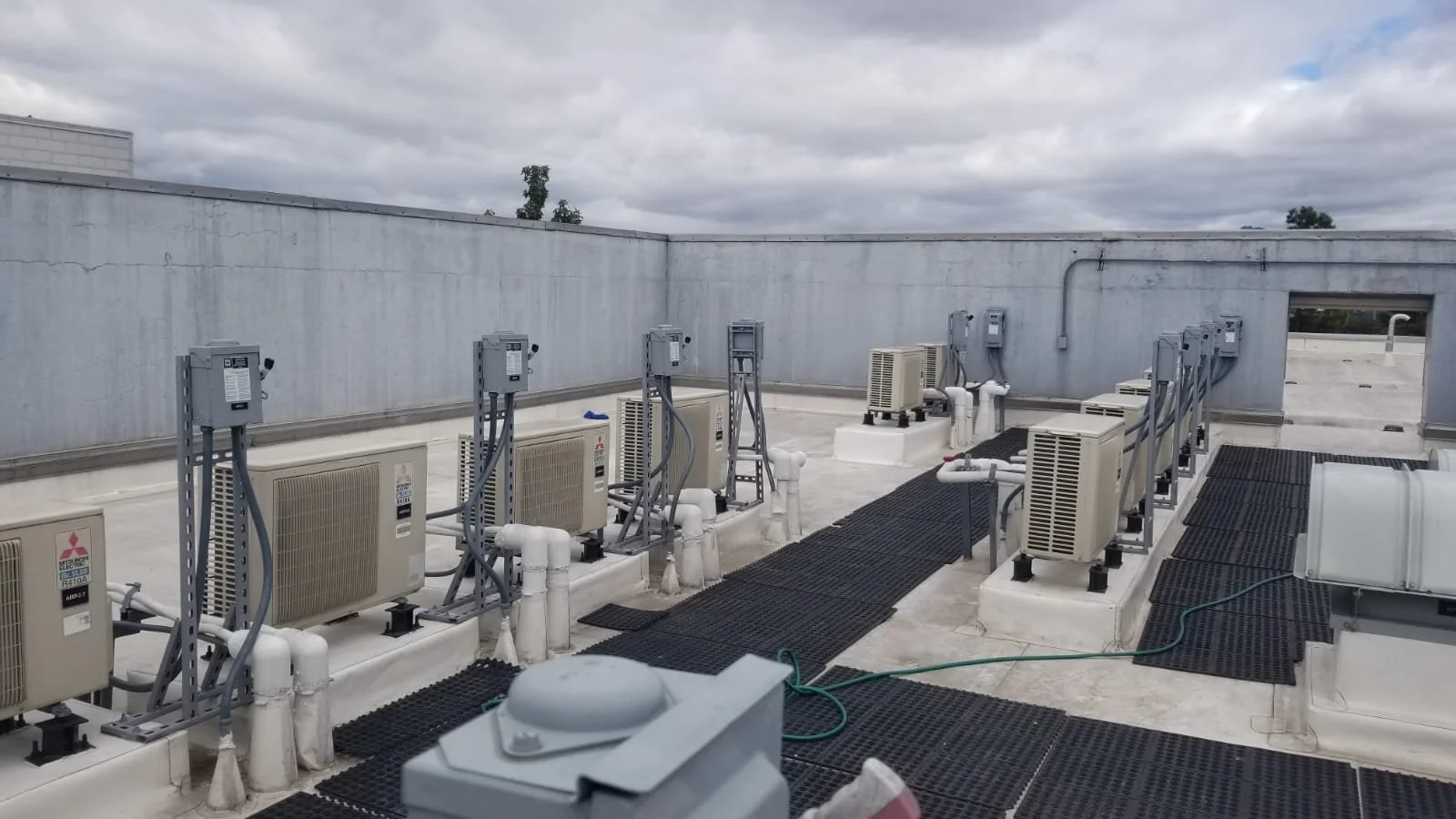 Techo de un edificio con unidades de aire acondicionado y conexiones eléctricas.