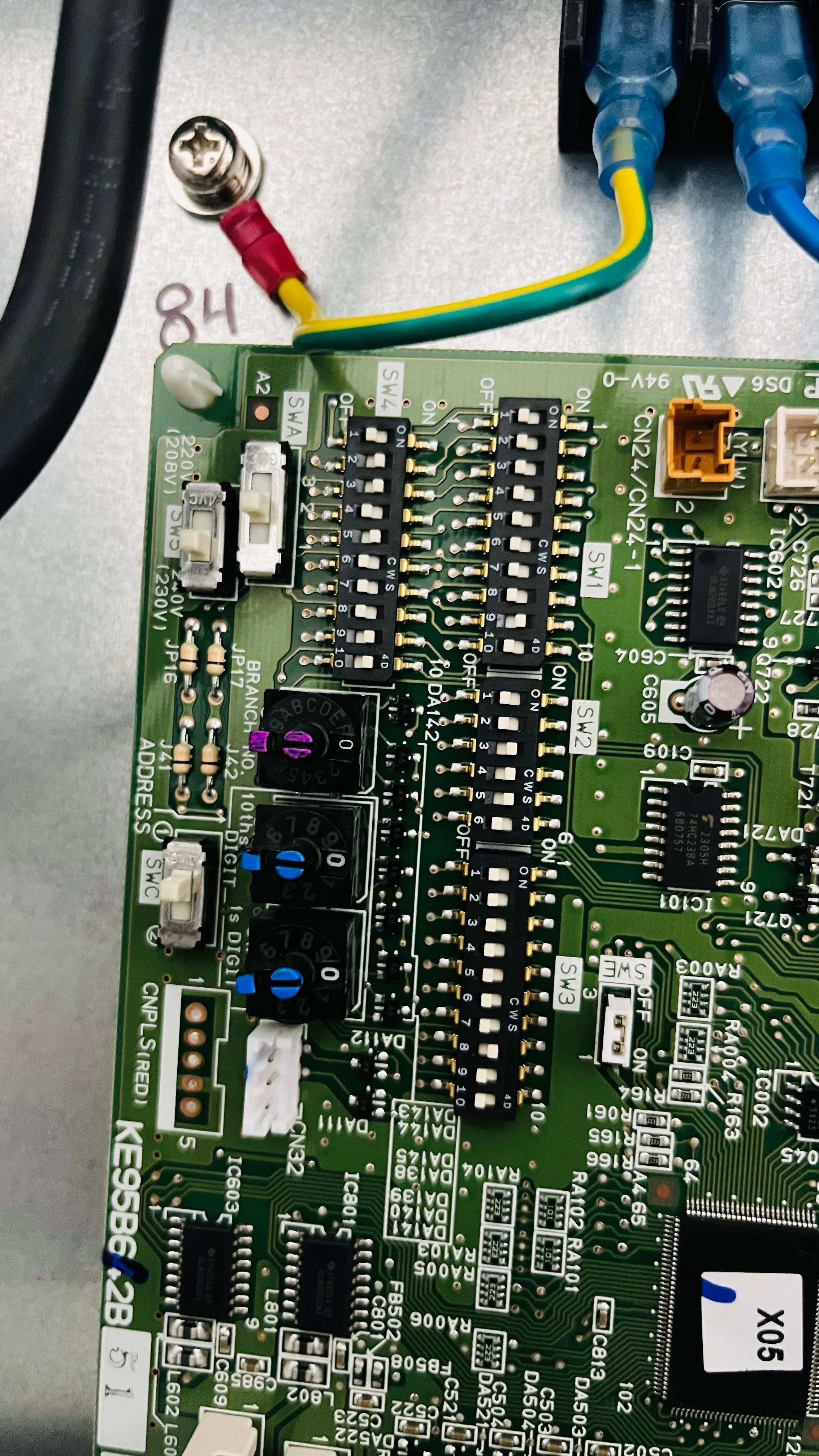 Tarjeta de circuito impreso con componentes electrónicos y conectores, incluyendo resistencias, capacitores, encoders y conectores de cables.