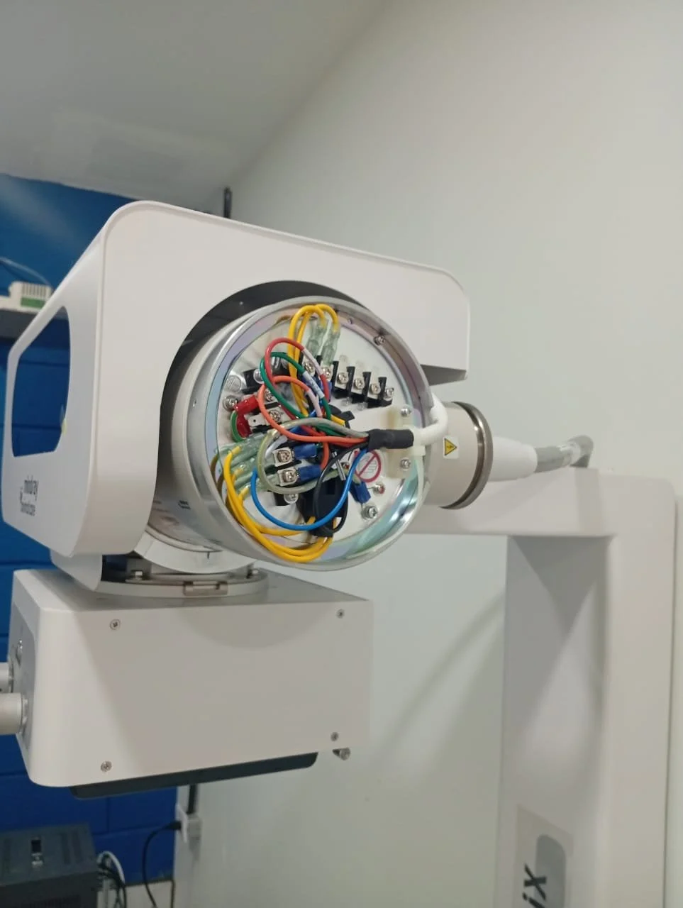 Imagen de un equipo médico con componentes electrónicos y cables expuestos, probablemente un equipo de rayos X o aparato de radioterapia.