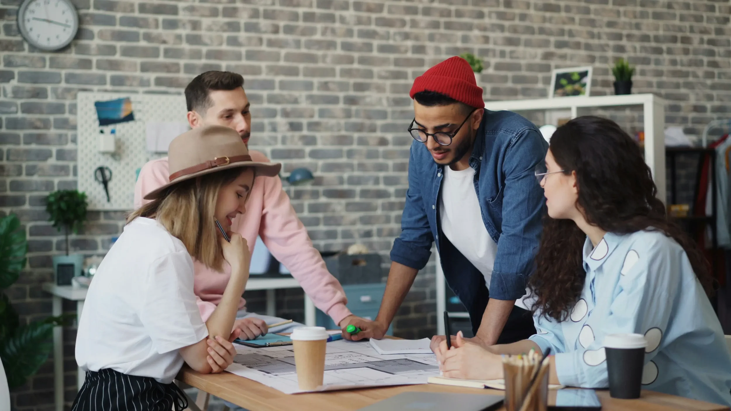 Group of co-workers collaborating on a project around a desk in the office