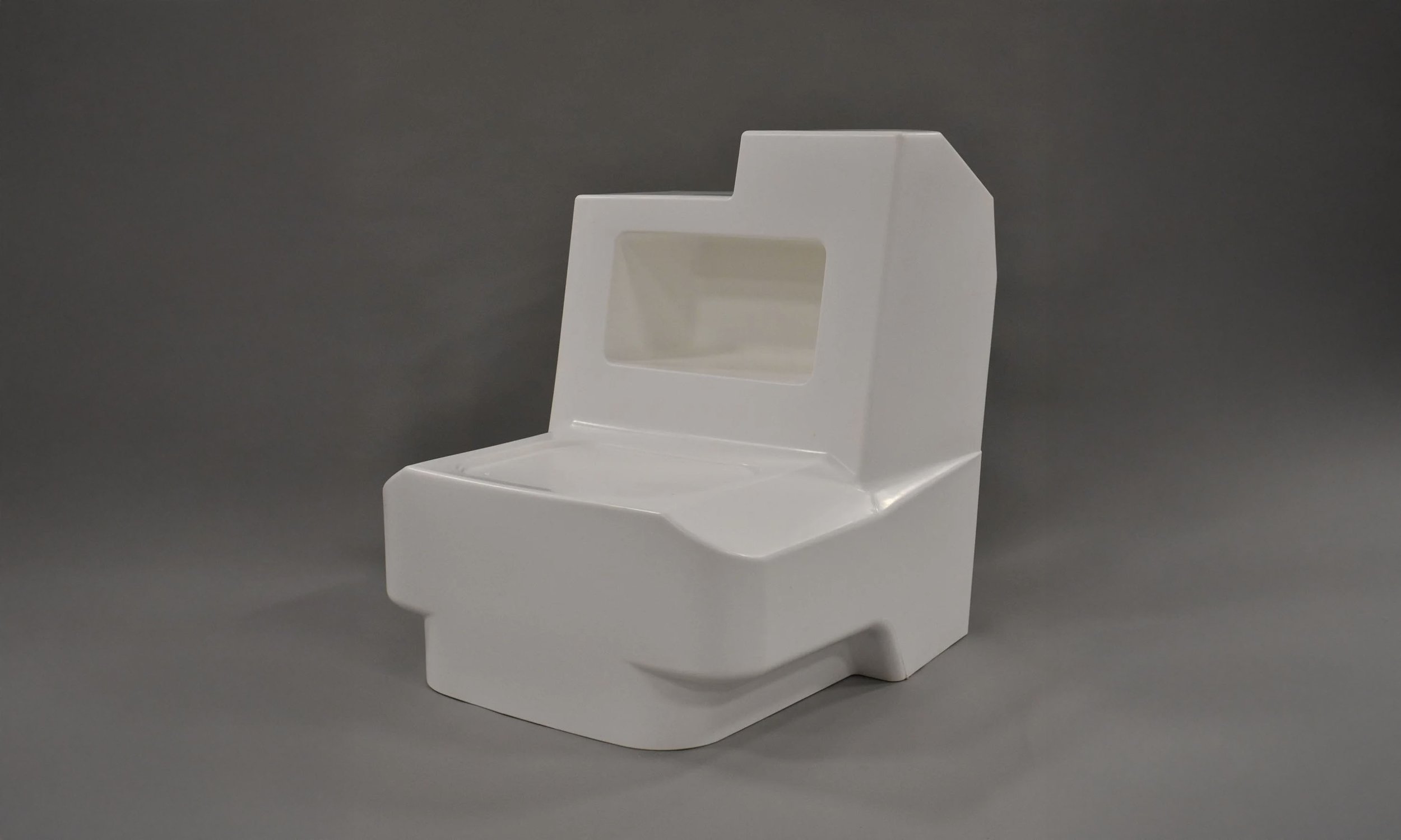A white plastic miniature toilet model against a gray background.