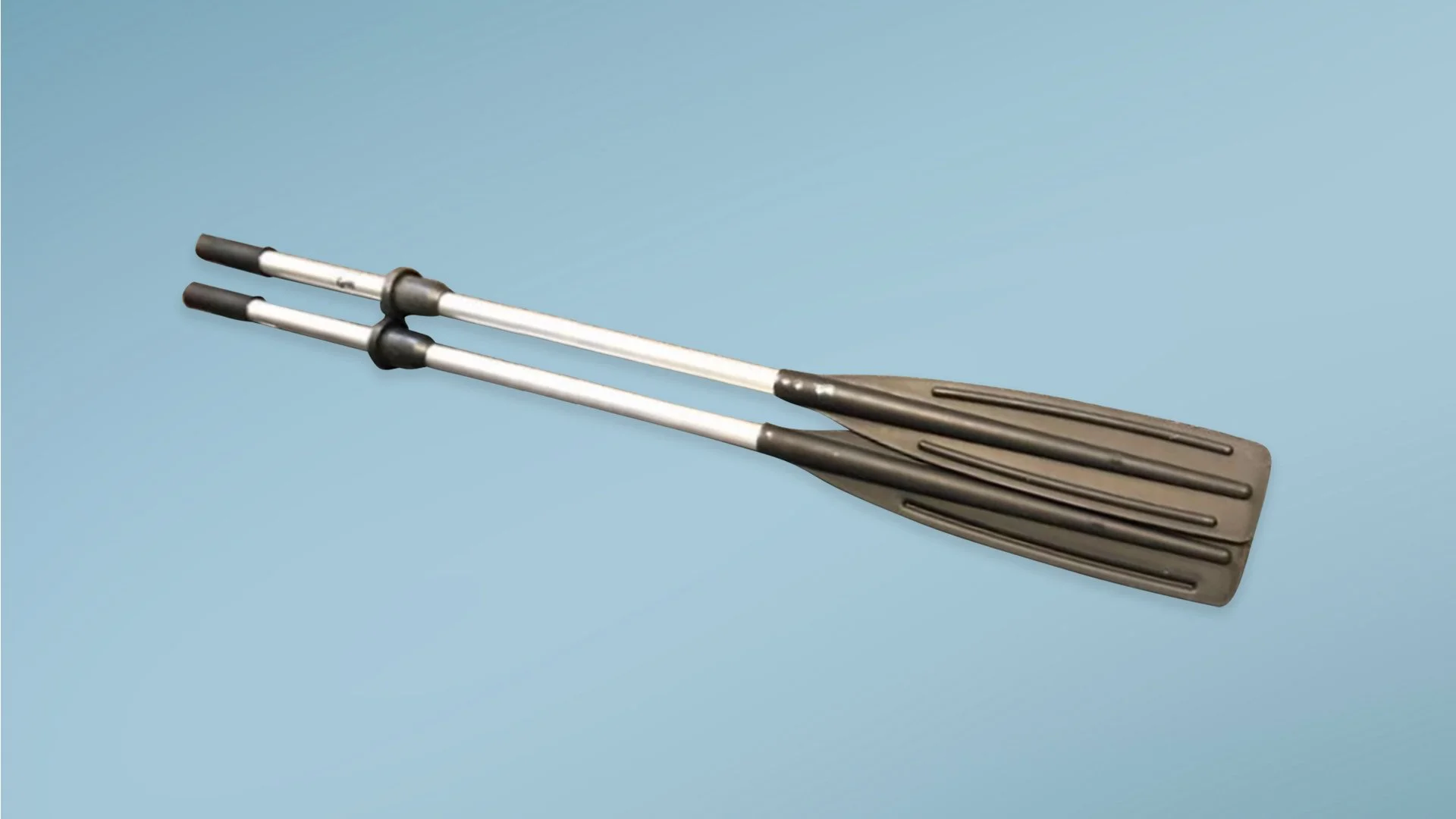 A pair of tennis or pickleball paddles with black handles and silver shafts, resting on a light blue surface.