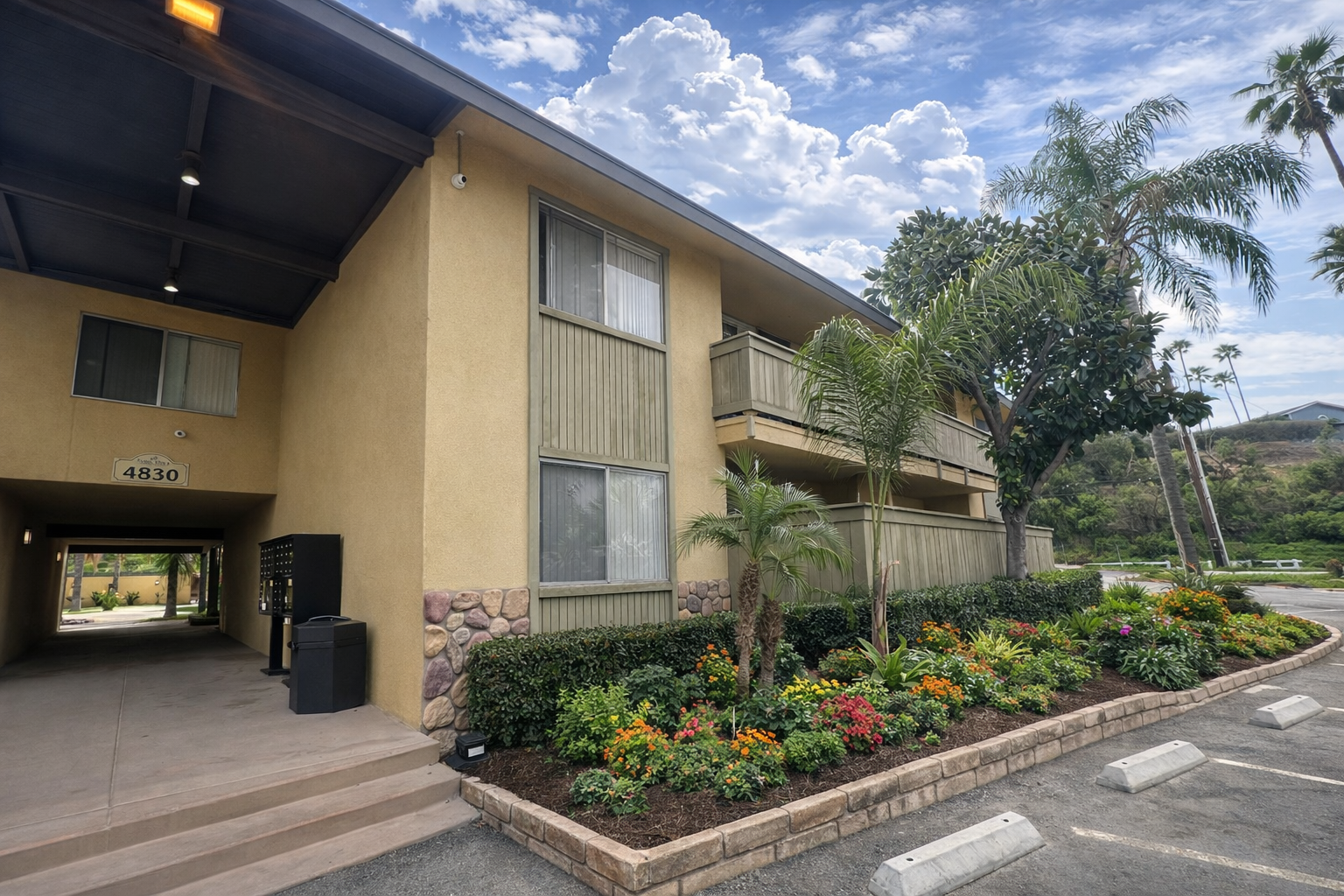 Retro exterior of Palm Vista Apartments surrounded by lush greenery 