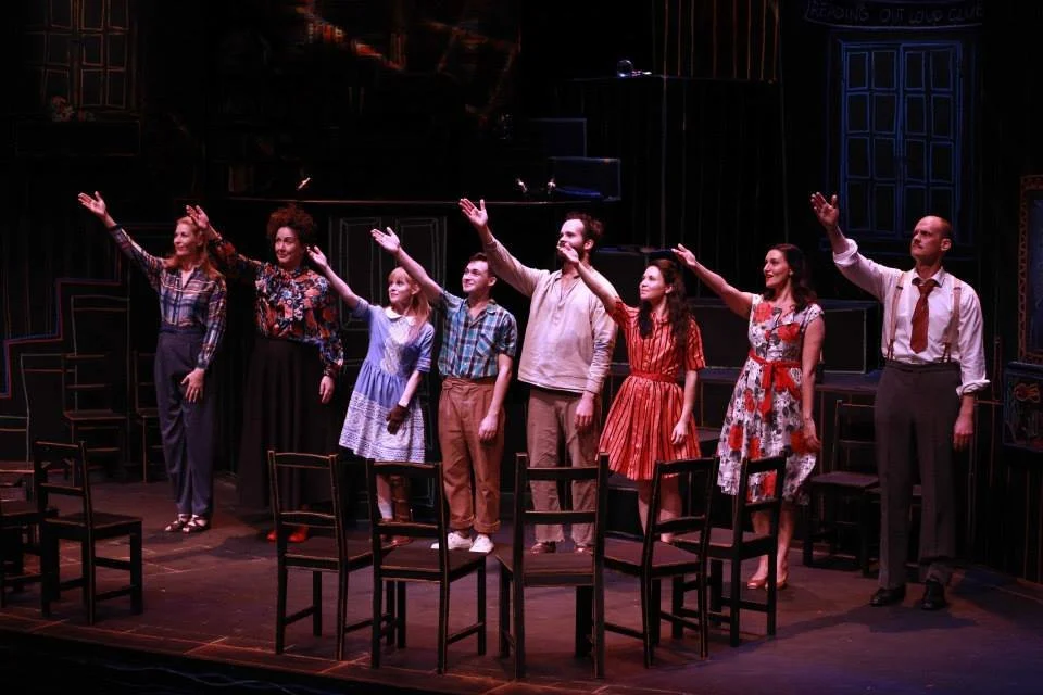 The cast of The Book of Everything with their hands up to thank the lighting operator in their final bows