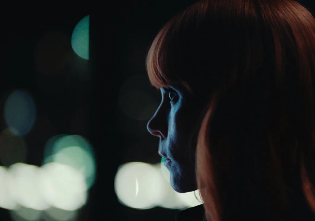 Actor Michelle Blundell in a film still from the short film Monologue. She is looking out a window into the night