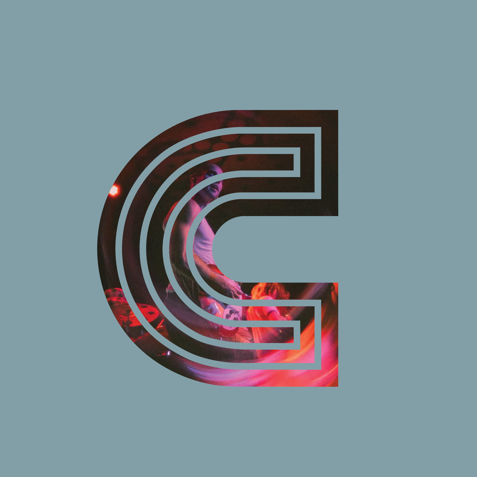 A large gray letter 'C' with a scene of a person sitting on a stage, illuminated by colorful lights, visible within the letter.