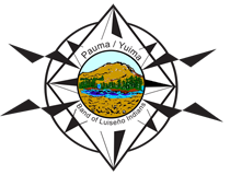 A circular emblem featuring a landscape with a river and mountains, surrounded by text that reads 'Pauma / Yuima Band of Luiseño Indians' and a decorative compass rose design.