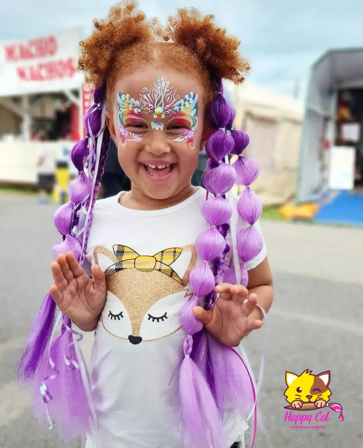 Excited young birthday girl with purple bubble braids and princess face paint at a Happy Cat Entertainment party in San Diego.
