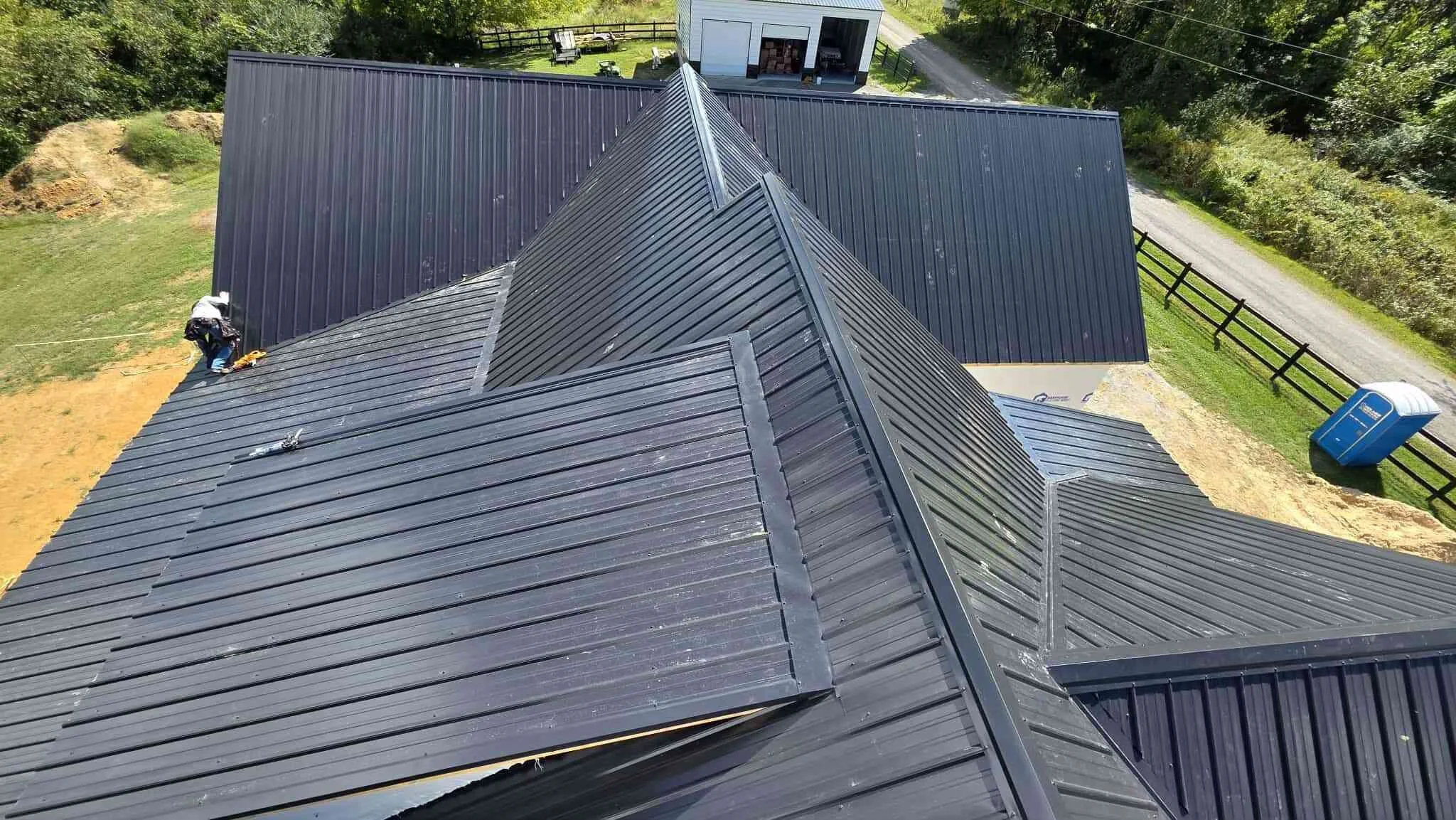 close up of dark standing seam metal roof installation with ridge cap in Middle Tennessee