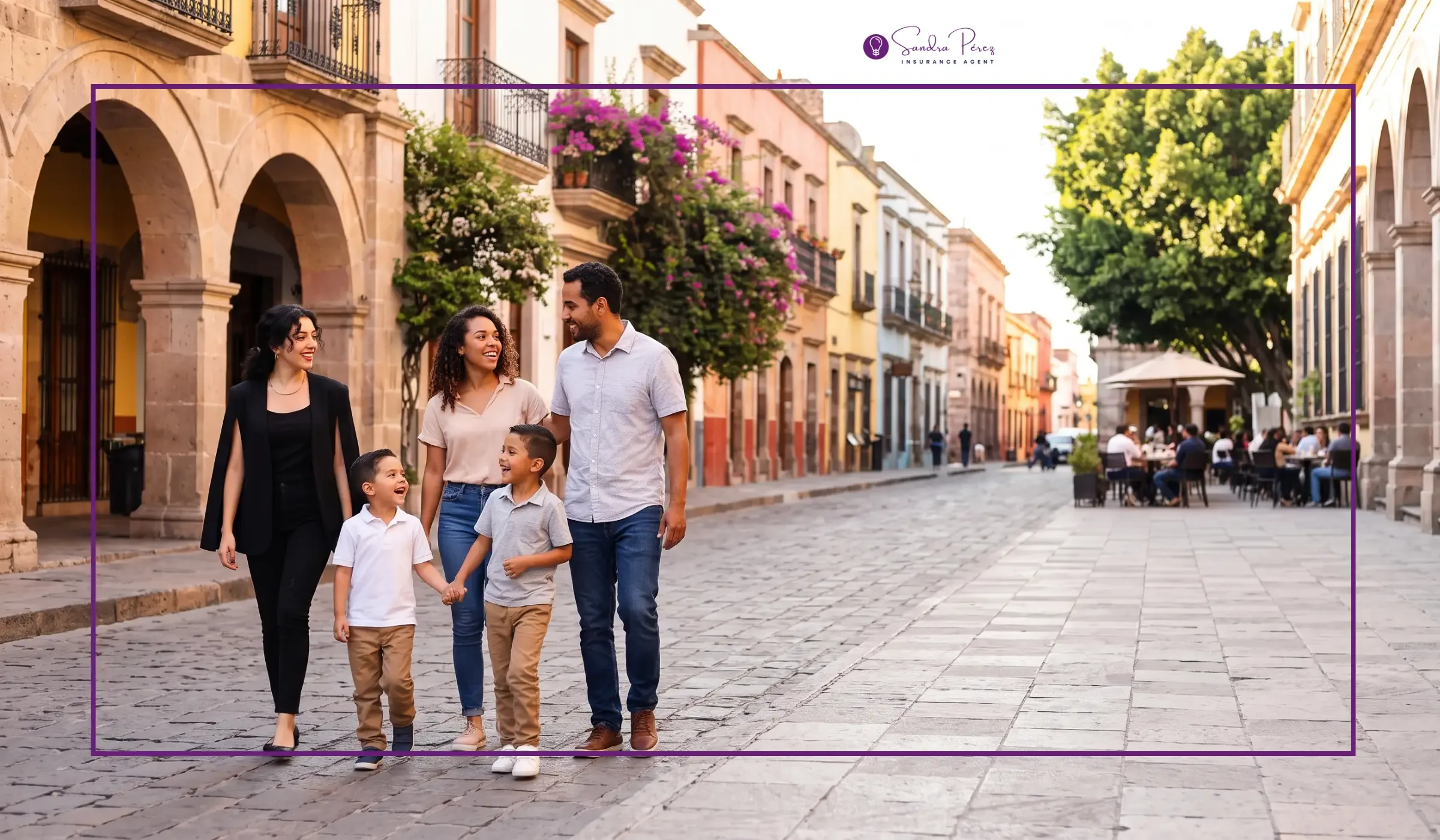 Familia caminando por una calle empedrada en un día soleado, con edificios coloridos y árboles.