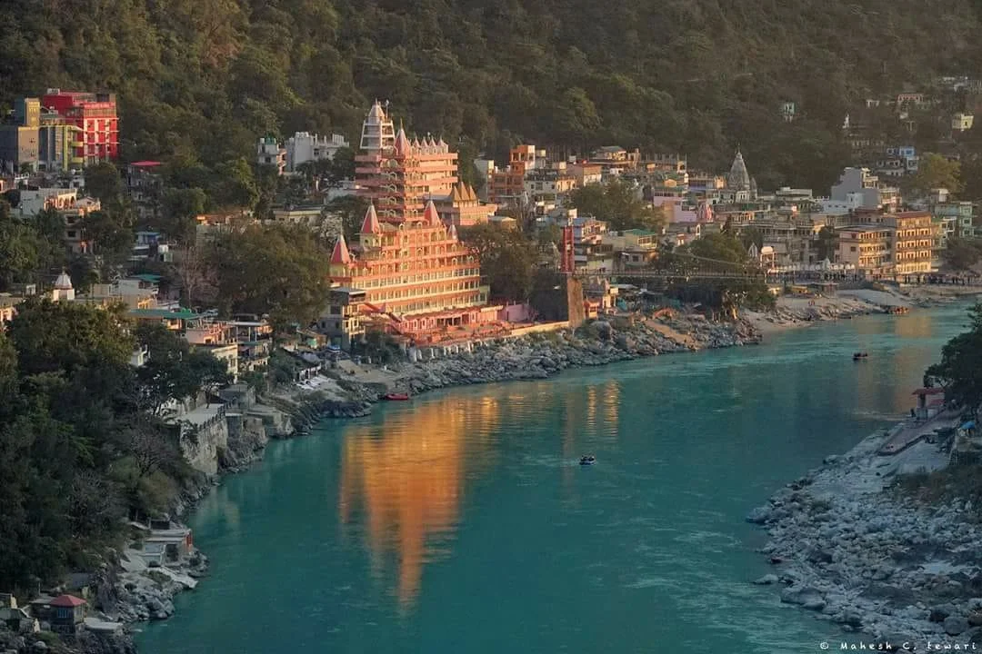 A coastal town with colorful buildings and hills in the background, USUALLY a river running along the shoreline.