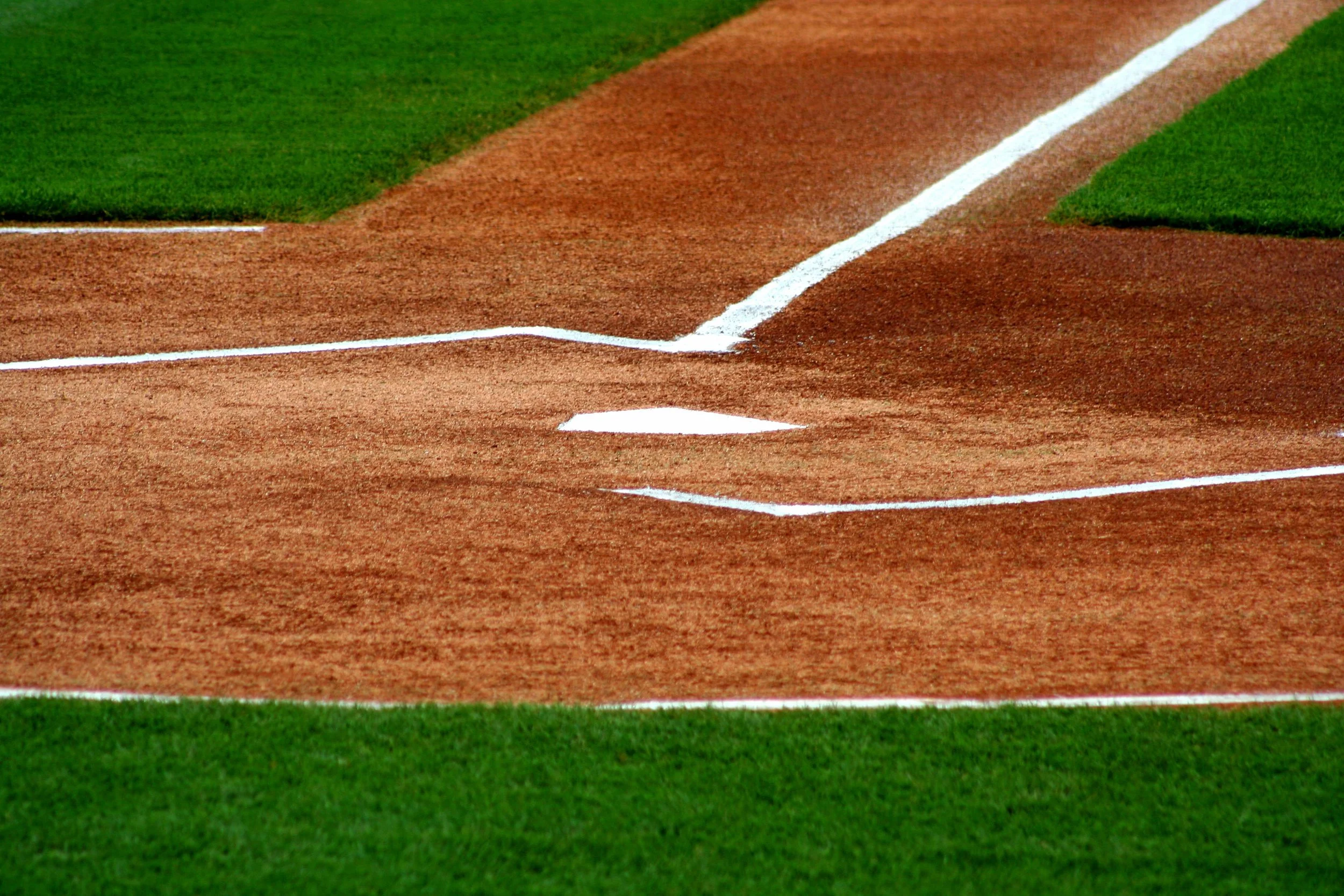 Close-up of a baseball field's home plate and surrounding white chalk lines.