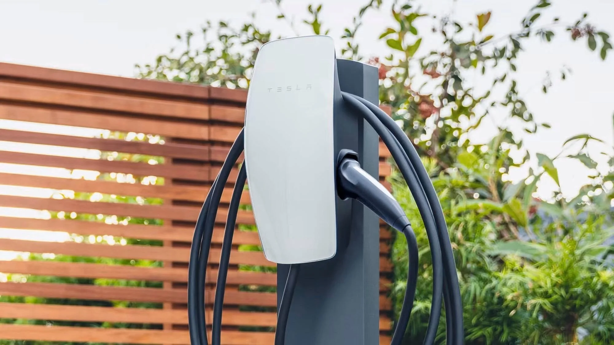 Tesla Wall Connector installed on wall with tethered charging cable