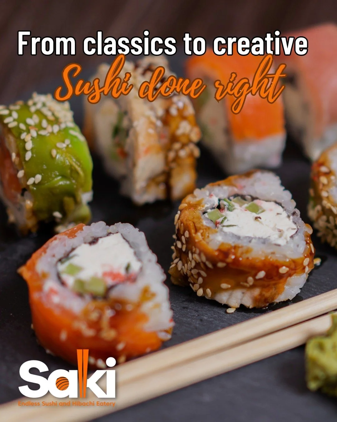 Assorted sushi rolls on a black slate platter with chopsticks, featuring various ingredients like fish, avocado, and sesame seeds.