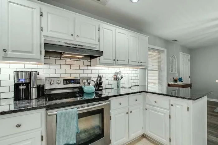 A kitchen that I changed for the owners. It involved painting the cabinets, new hardware on the cabinets, tile backsplash, under cabinet lights, paint and coordinated the countertops with the overall project for the owners.