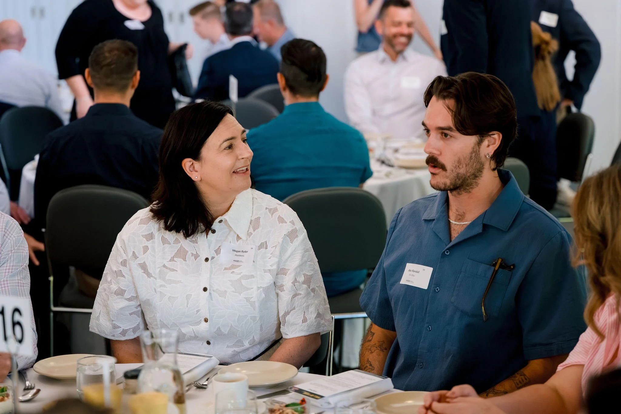 People seated at a banquet table during a social event, engaged in conversation