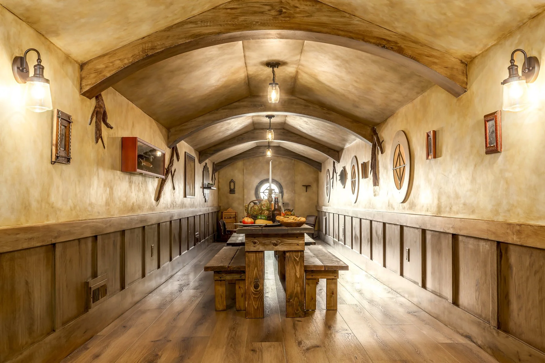 A rustic dining room with wooden furniture, including a long table, benches, and wall decorations, and warm lighting.