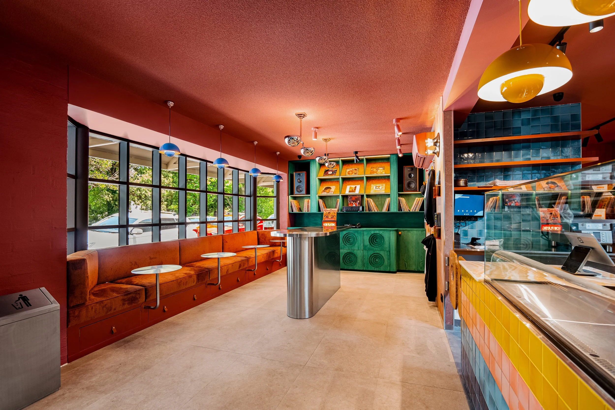 An image of the vinyl booth and window banquette with stainless steel bench and tables.