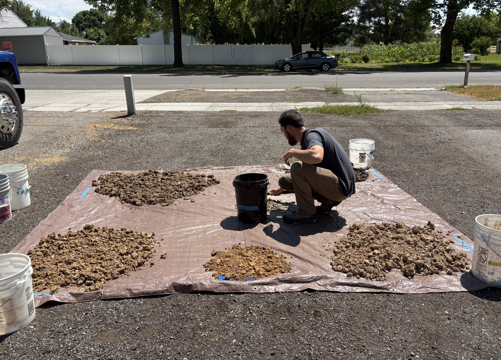 Adam Corbridge spreading piles of dug wild clay on a tarp to dry