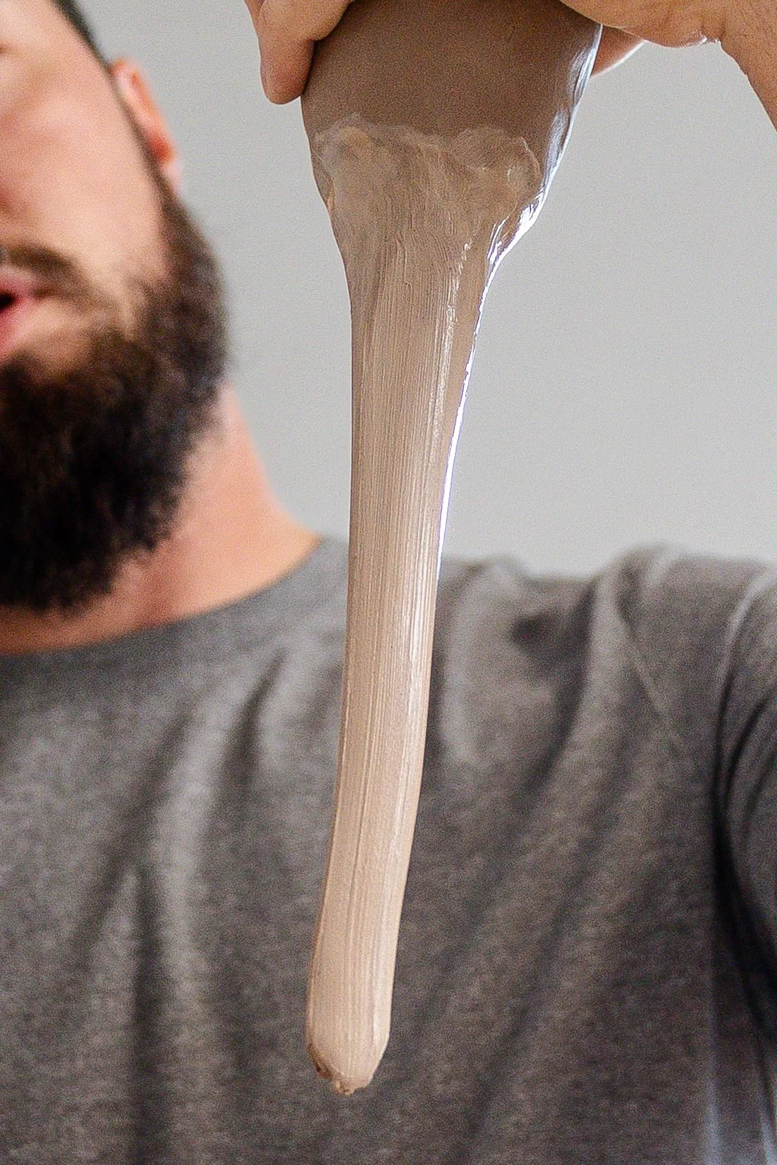 A long tapered clay handle being pulled from a lump of clay