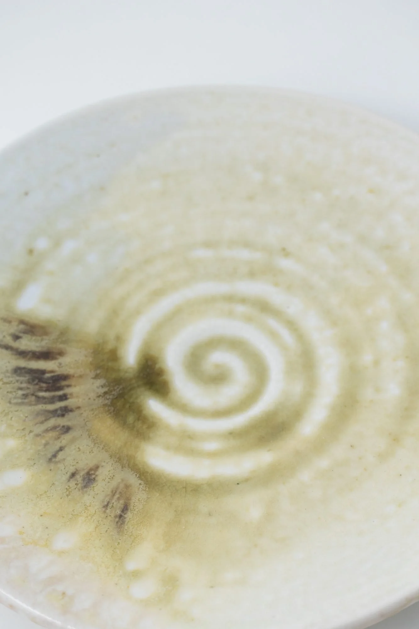 Close view of a pale plate with a green spiral at its center