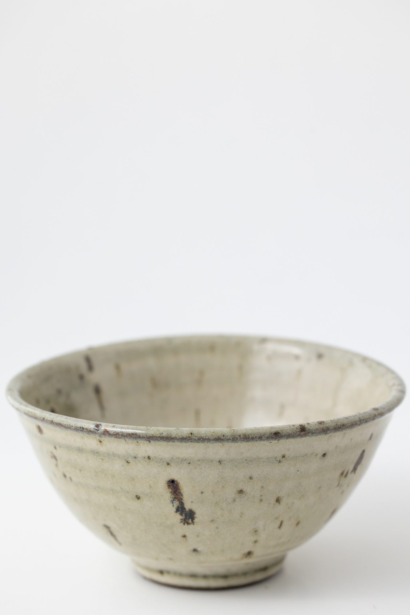 A pale speckled bowl on a white background