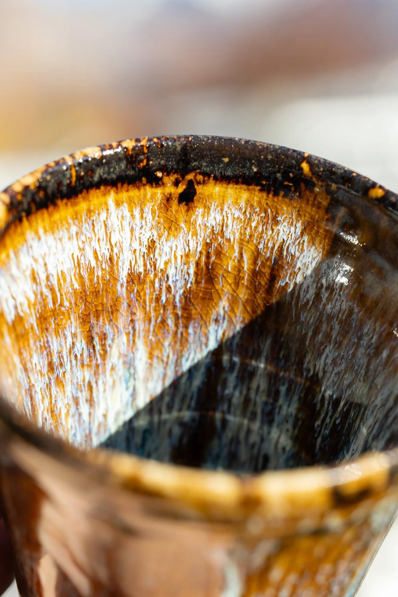 Looking into a glazed cup with amber streaks running down to a dark center