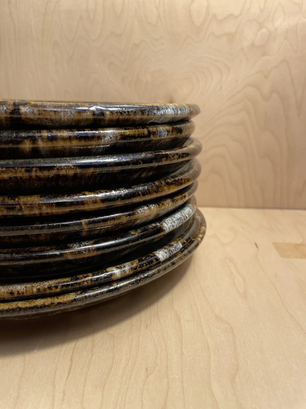 Close view of the edges of a stack of dark glazed plates