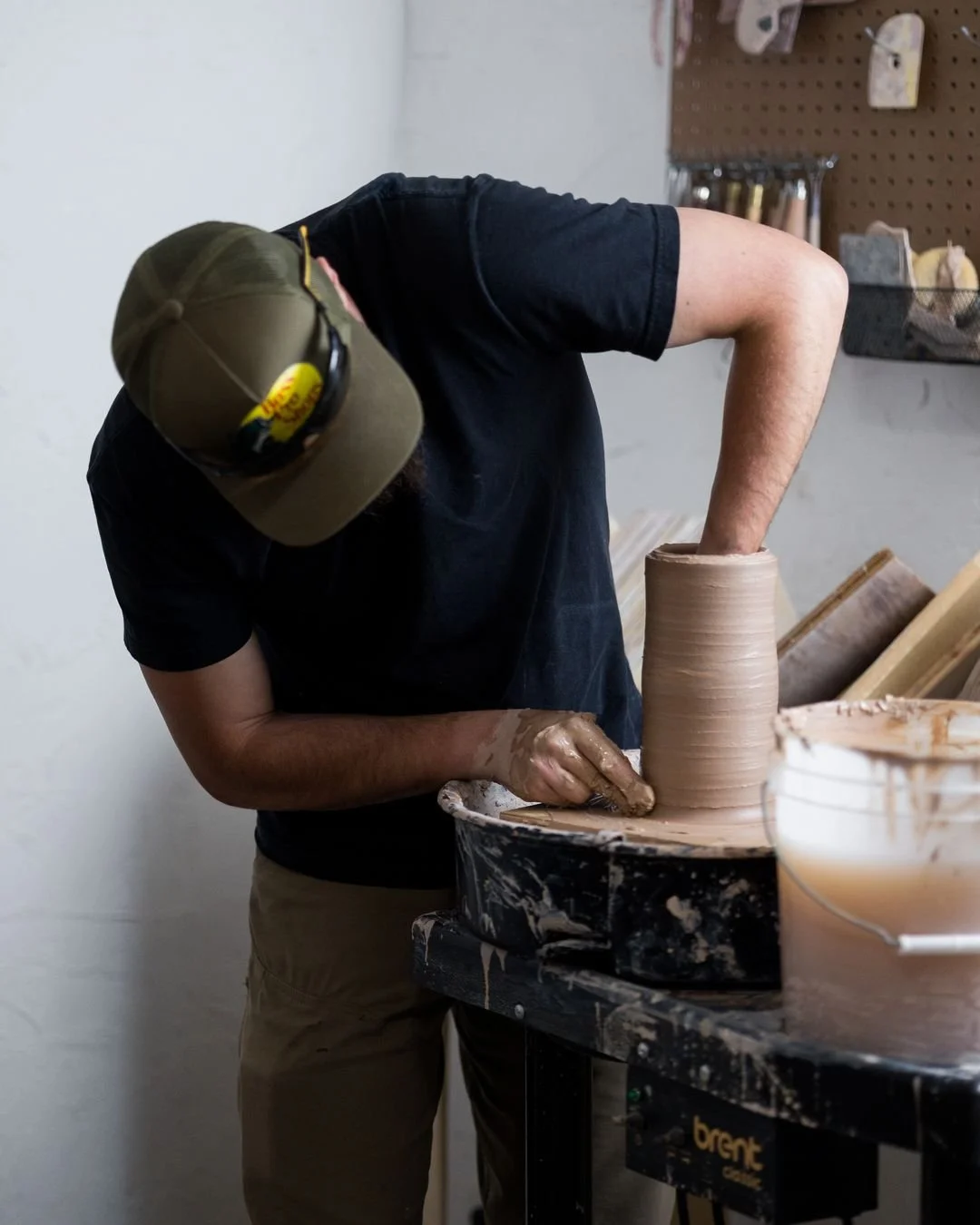 Every square foot counts in this studio.

The wheel is tucked against the wall, the water bucket stays within reach, and most of my tools live right above the wheel on a pegboard. The pug mill sits on a rolling table so I can move it out of the way w