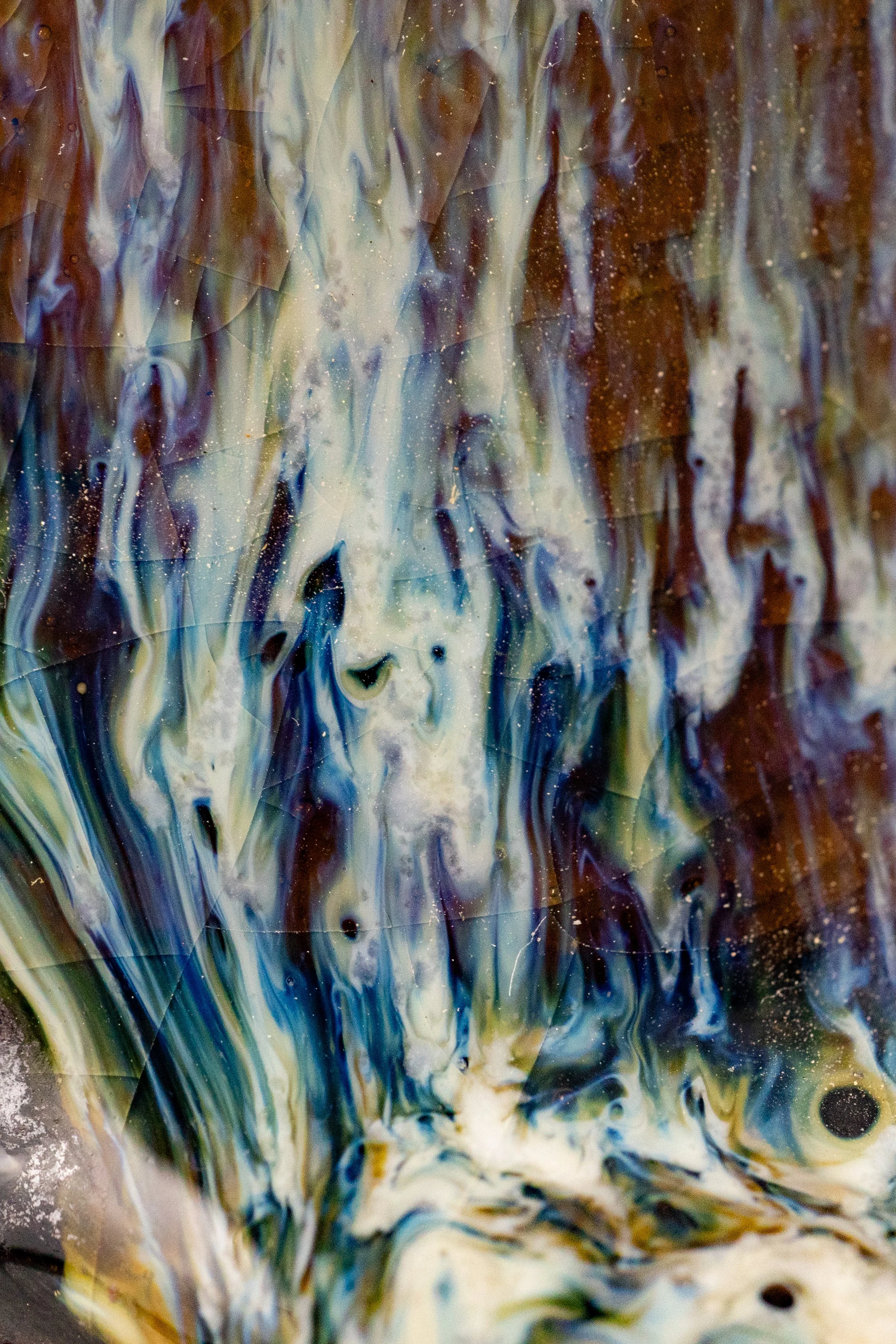 Close-up of blue, white and amber glaze streaks on a salt-fired pot