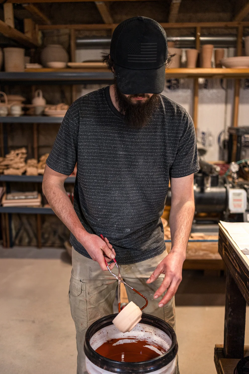 Adam glazing test tiles made from wild clay in the studio