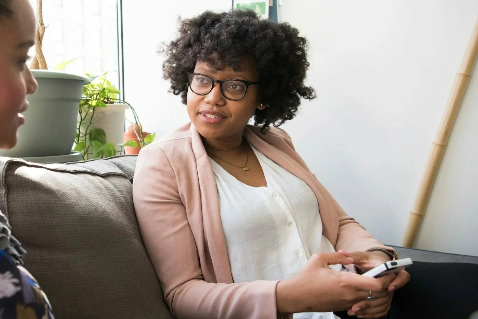 Two people, one with dark skin and the other with light skin, fist-bumping against a textured white wall background.