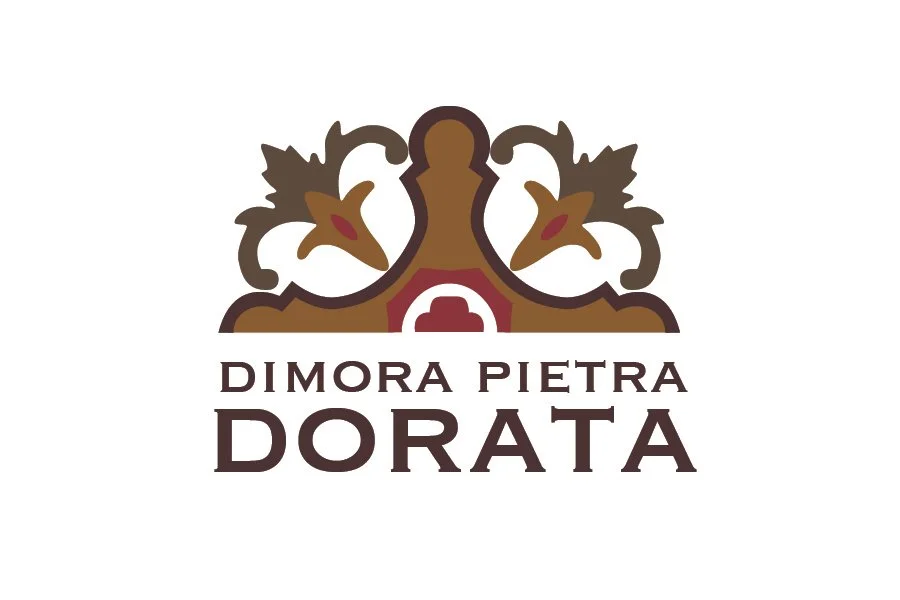 A logo with a decorative design resembling a crown or ornate architectural element, followed by the text 'Dimora Pietra Dorata' in stylized font.